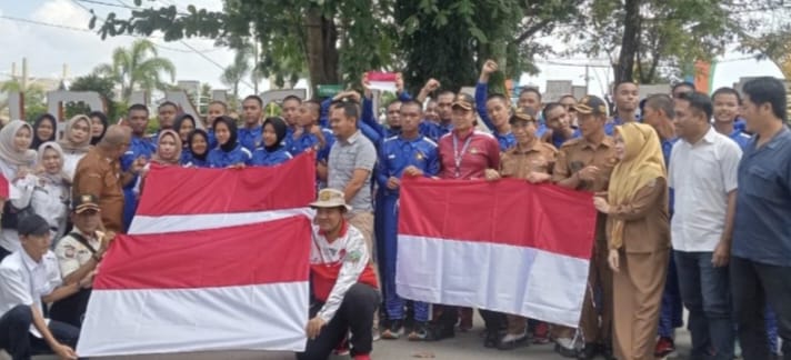 Kepala Dinas Kesbangpol Kotabaru Bagikan Bendera Merah Putih di Siring Laut